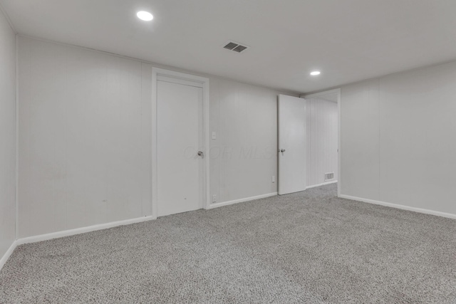 carpeted empty room featuring baseboards, visible vents, and recessed lighting