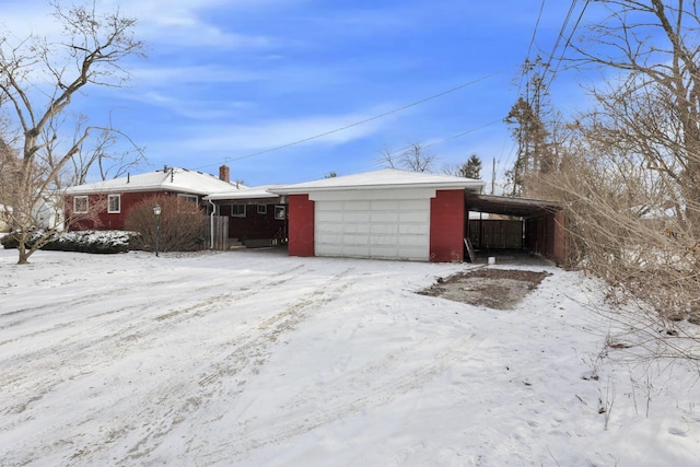 exterior space featuring a carport, a chimney, and a garage