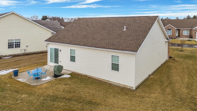 rear view of house featuring a patio area, a lawn, and roof with shingles