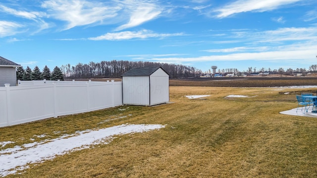 view of yard featuring an outbuilding, a storage unit, and fence