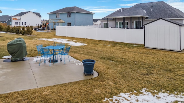 view of yard with an outbuilding, fence, a patio area, a shed, and outdoor dining space