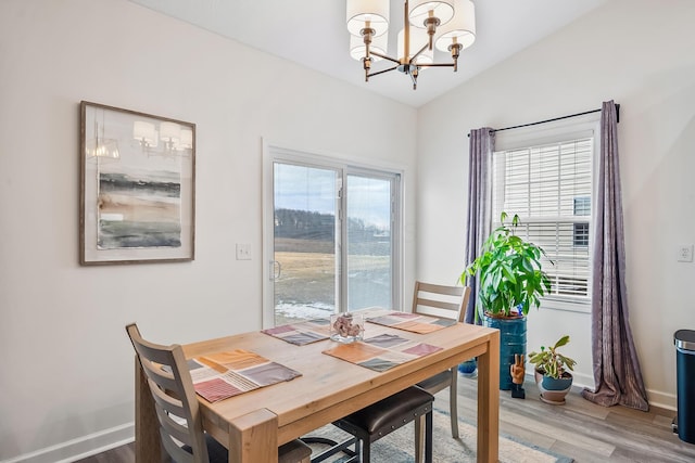 dining room featuring baseboards, a chandelier, a wealth of natural light, and wood finished floors