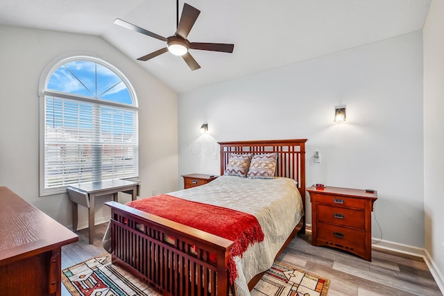 bedroom with light wood-style floors, vaulted ceiling, baseboards, and a ceiling fan