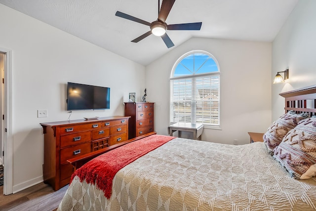 bedroom featuring a ceiling fan, lofted ceiling, baseboards, and light wood finished floors