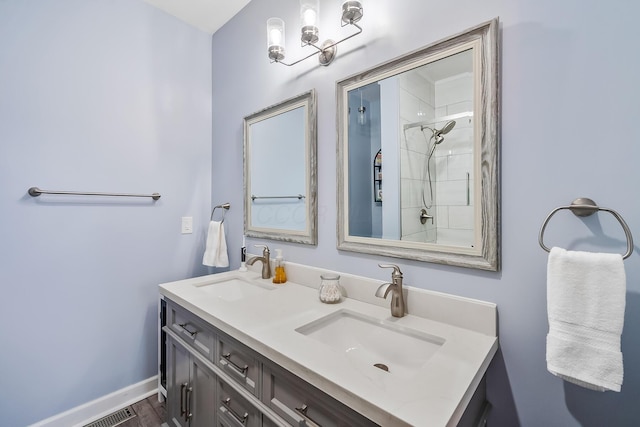 bathroom featuring wood finished floors, a sink, baseboards, and double vanity