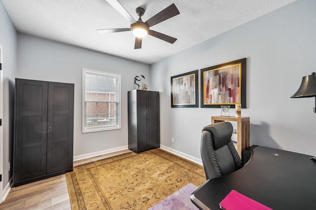 office space featuring light wood-style flooring, baseboards, and a ceiling fan