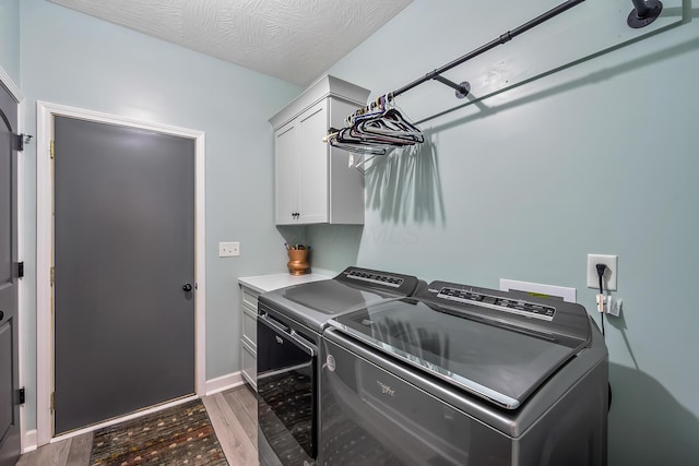 clothes washing area featuring cabinet space, baseboards, washer and clothes dryer, dark wood-style floors, and a textured ceiling