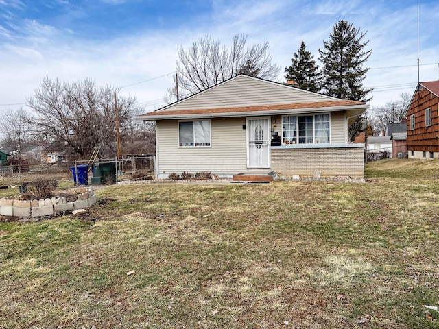 bungalow-style house with fence and a front lawn