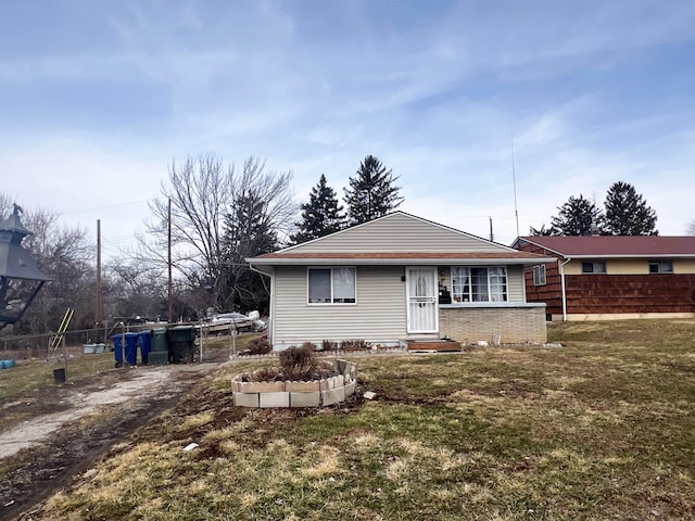 rear view of house featuring fence and a lawn