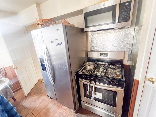 kitchen with light wood finished floors and appliances with stainless steel finishes