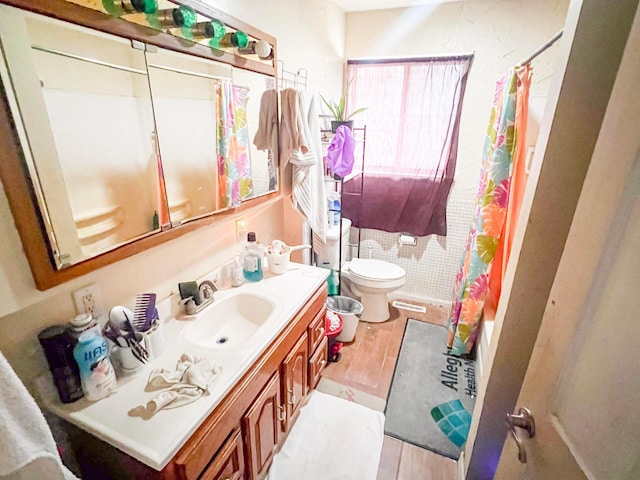 bathroom featuring visible vents, toilet, wood finished floors, shower / bath combination with curtain, and vanity