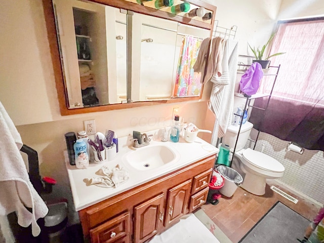 bathroom featuring toilet, vanity, and visible vents