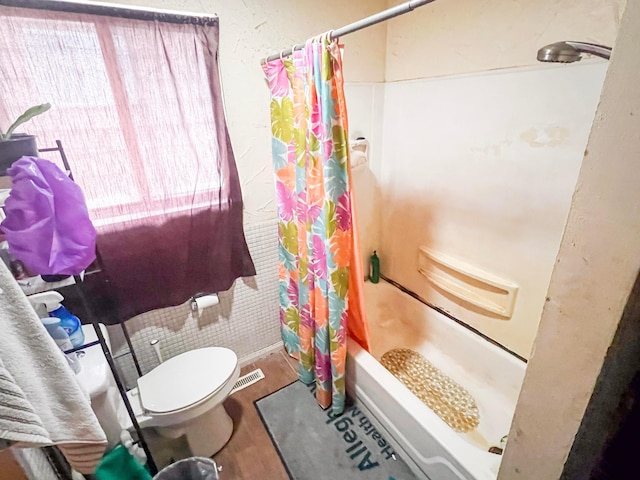 full bath with toilet, shower / bath combo with shower curtain, and wood finished floors