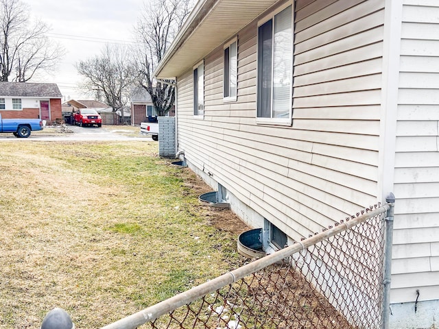 view of side of property with fence and a yard