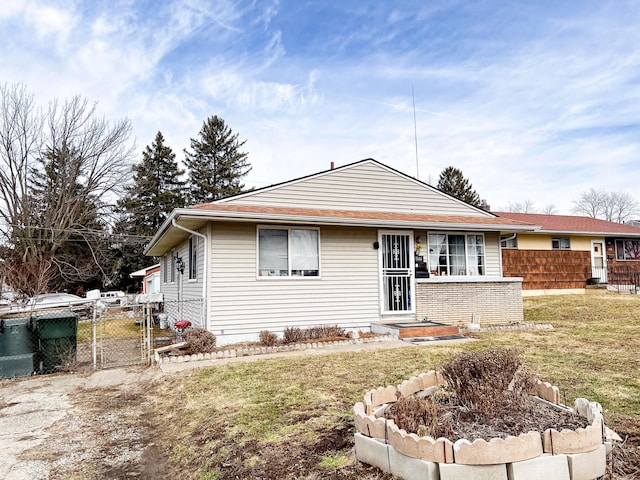 ranch-style house with a front yard, fence, and a gate