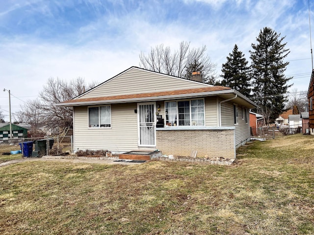 bungalow featuring fence, a chimney, and a front lawn