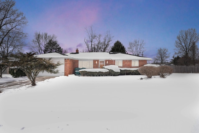 view of front of home with a garage, brick siding, fence, and a chimney