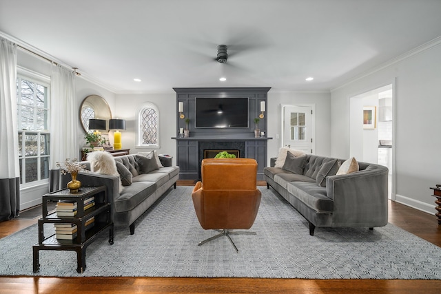 living area with ornamental molding, dark wood-style flooring, a fireplace, and recessed lighting