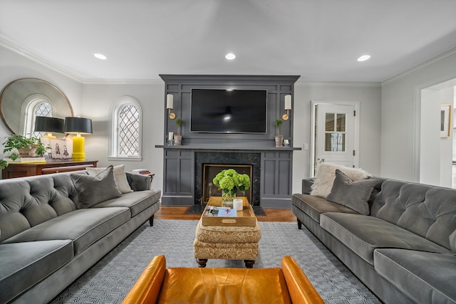 living room featuring dark wood-type flooring, recessed lighting, a fireplace, and crown molding