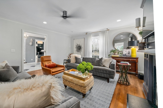 living area with recessed lighting, wood finished floors, a ceiling fan, and crown molding