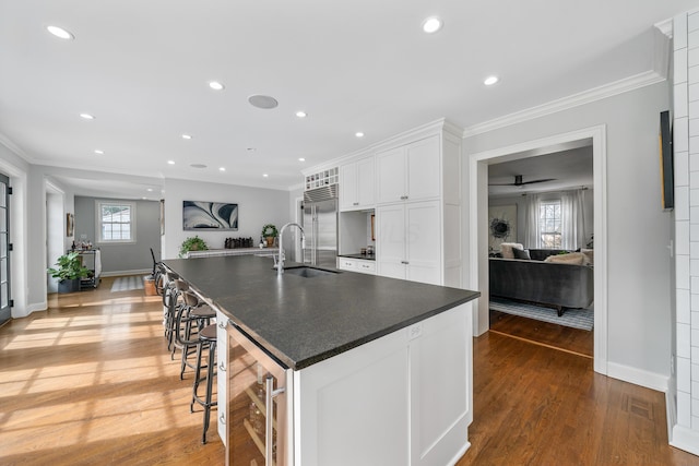 kitchen featuring dark countertops, a spacious island, white cabinetry, and open floor plan