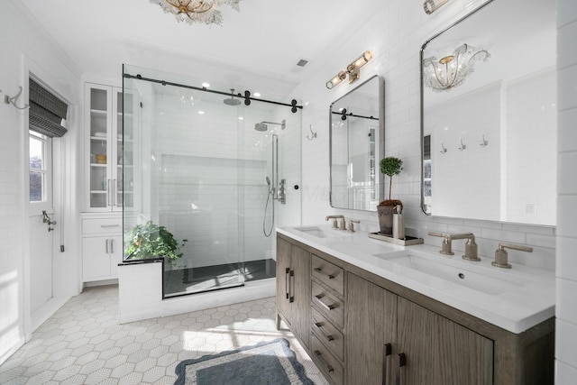 bathroom featuring double vanity, a shower stall, decorative backsplash, and a sink