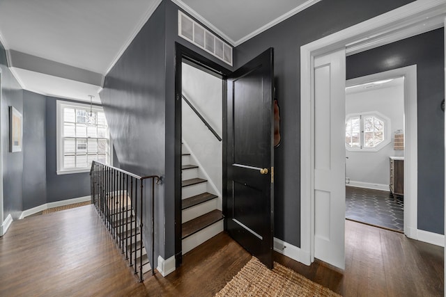 stairway with baseboards, crown molding, visible vents, and wood finished floors