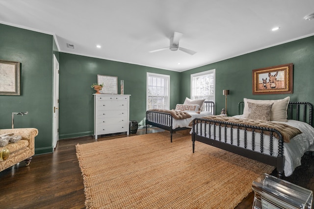 bedroom with dark wood-style flooring, visible vents, crown molding, and baseboards