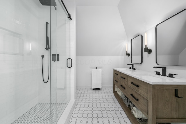 full bath with vaulted ceiling, double vanity, a sink, and a shower stall