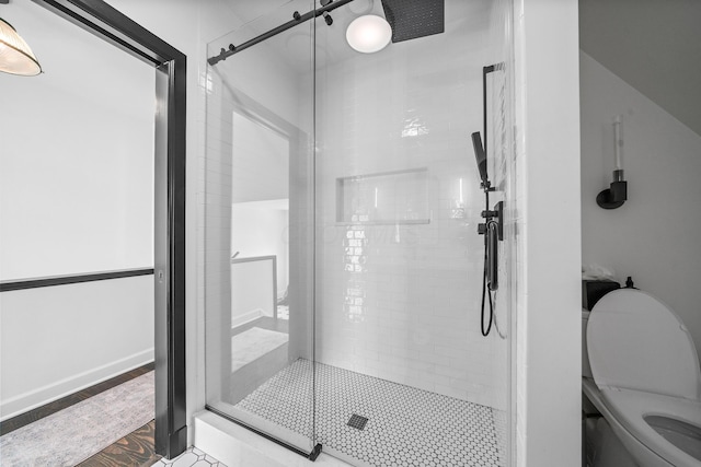 full bathroom featuring a stall shower and toilet