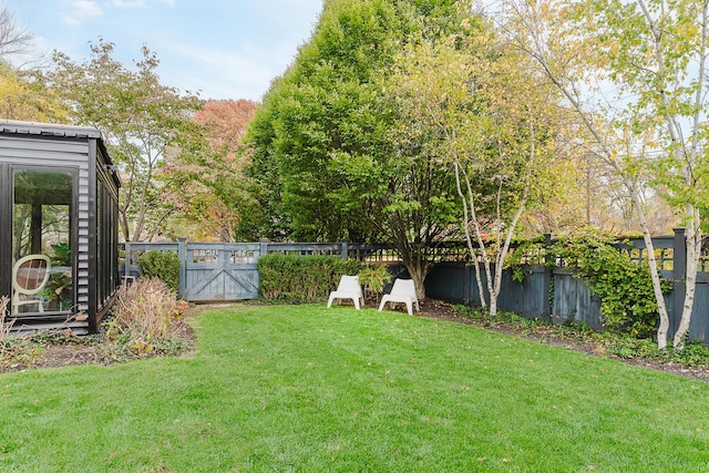 view of yard with a fenced backyard and a gate