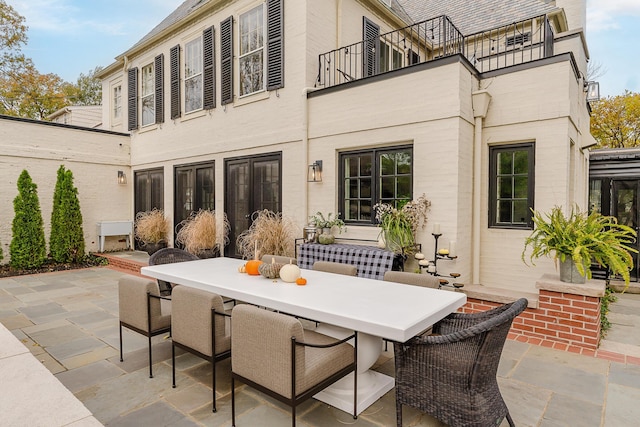 view of patio featuring a balcony and outdoor dining area