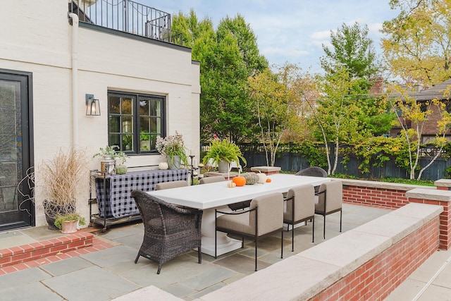 view of patio featuring outdoor dining space and fence