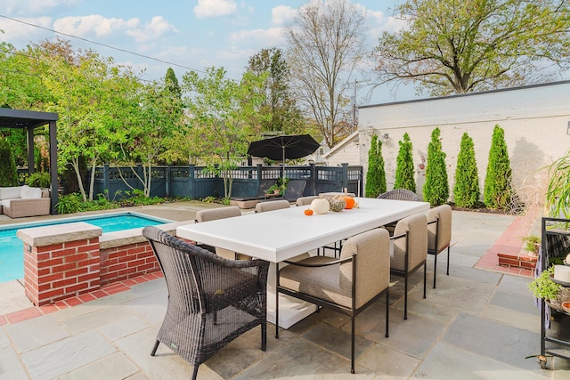 view of patio with outdoor dining space, fence, and a fenced in pool