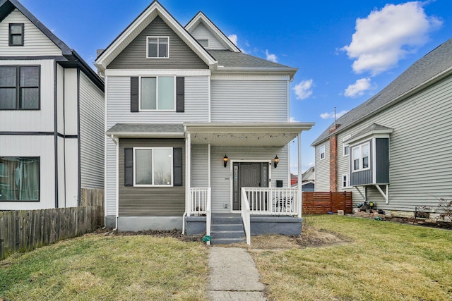 view of front of home with a porch, fence, and a front lawn