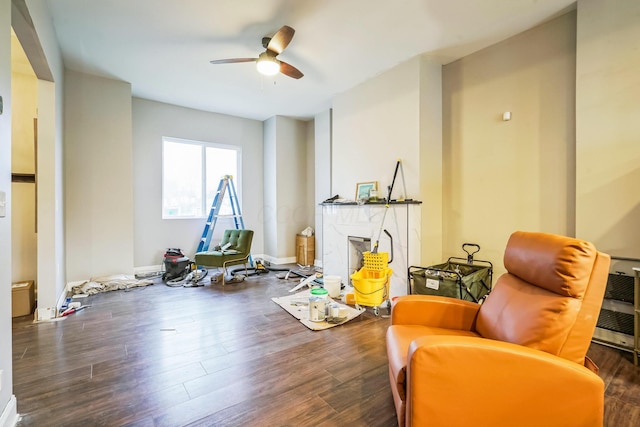 workout room featuring ceiling fan, dark wood-style flooring, a high end fireplace, and baseboards