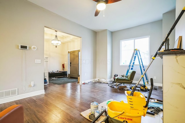 workout area with baseboards, visible vents, and dark wood finished floors