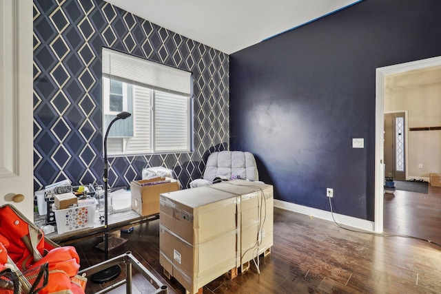 office area with an accent wall, dark wood finished floors, baseboards, and wallpapered walls