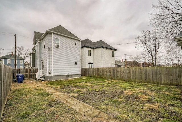 rear view of house with a lawn, a fenced backyard, and a residential view