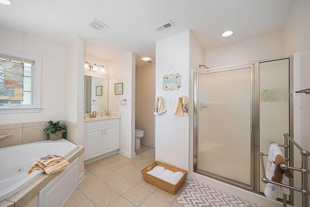 bathroom featuring toilet, vanity, visible vents, tile patterned floors, and a stall shower