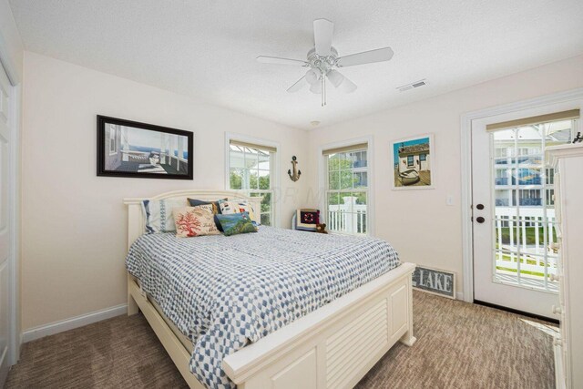 bedroom with a textured ceiling, access to outside, carpet flooring, and visible vents