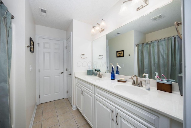 bathroom with tile patterned flooring, visible vents, and a sink