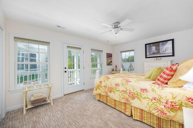 carpeted bedroom with access to outside, baseboards, ceiling fan, and a textured ceiling