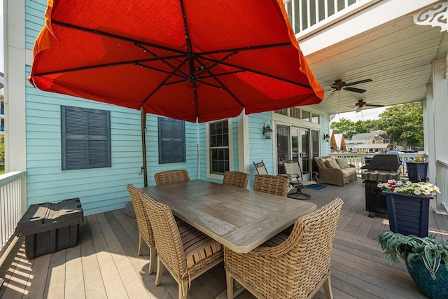 wooden terrace featuring outdoor dining space and ceiling fan