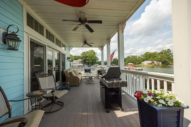 deck featuring ceiling fan, grilling area, and a water view