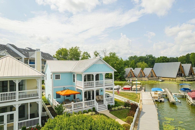 rear view of house with a water view and a balcony