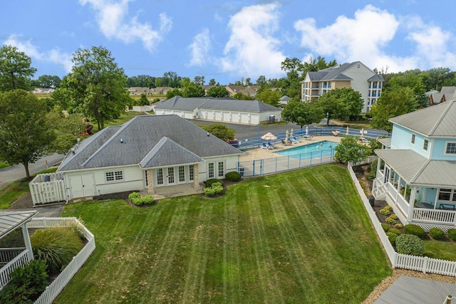 rear view of property with a fenced backyard, a yard, french doors, a fenced in pool, and a patio area