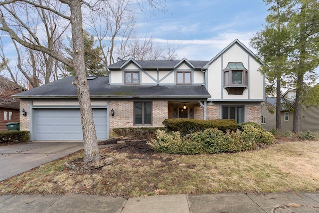 english style home with driveway, brick siding, roof with shingles, and an attached garage