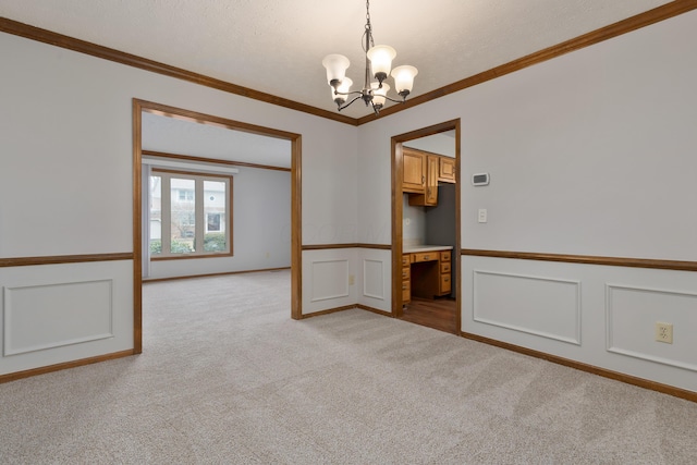 empty room with a chandelier, a decorative wall, light carpet, a wainscoted wall, and crown molding