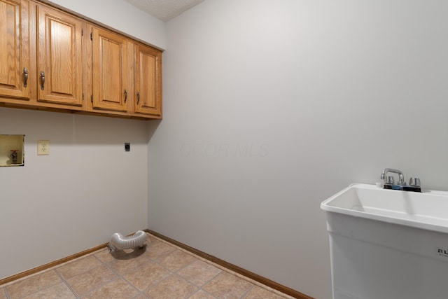 washroom featuring washer hookup, cabinet space, a sink, electric dryer hookup, and baseboards